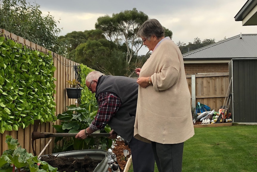 Two older people gardening.
