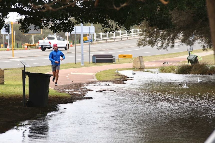 Jogger approached footpath that is submerged