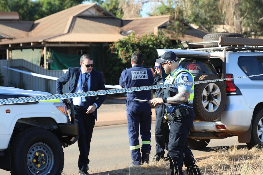 Detectives and other investigators gather outside a house in Port Hedland