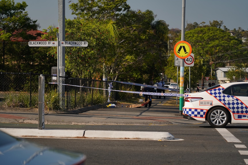 a footpath surrounded by police crime scene tape with evidence markers on the ground