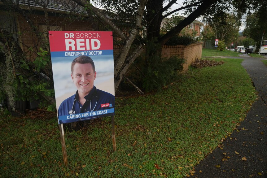 A corflute of Gordon Reid infront of a house