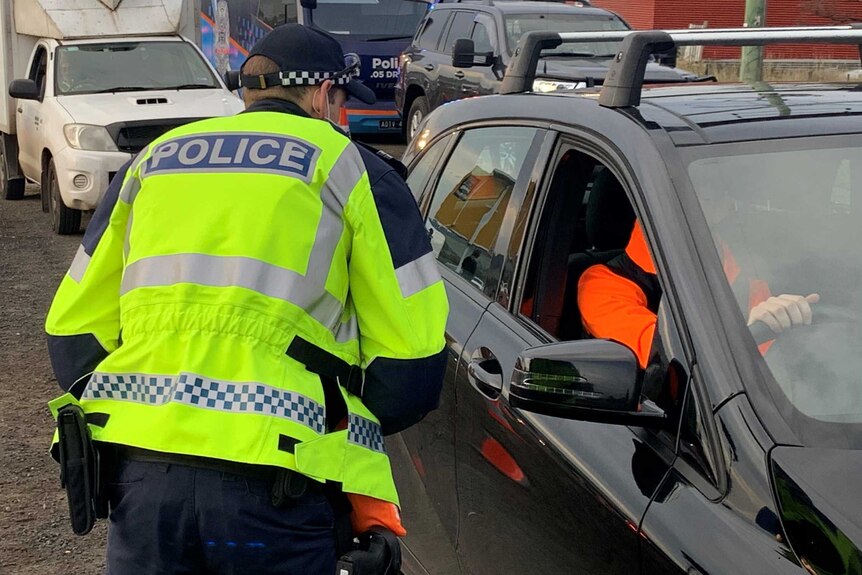 A police officer speaks to a motorist at a checkpoint at Gisborne.