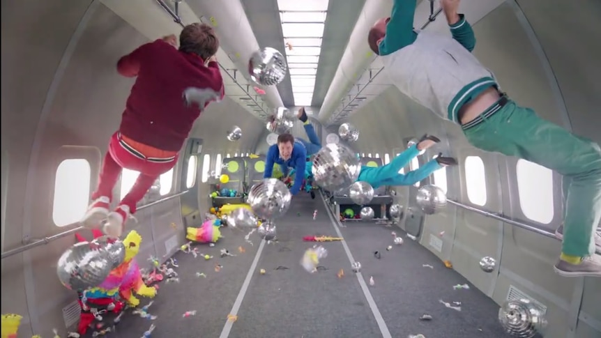 A screenshot from the OK Go video Upside Down & Inside Out shows band members floating in zero gravity