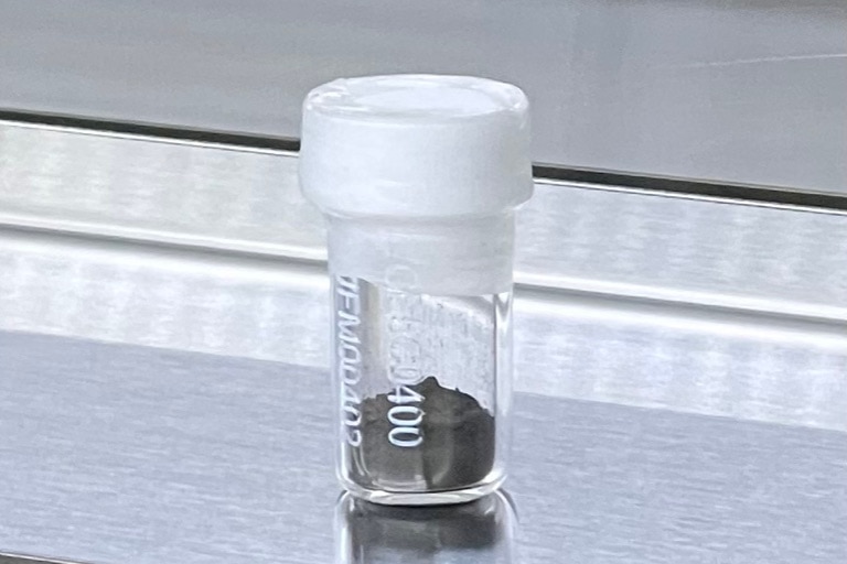 A small plastic jar with gray soil