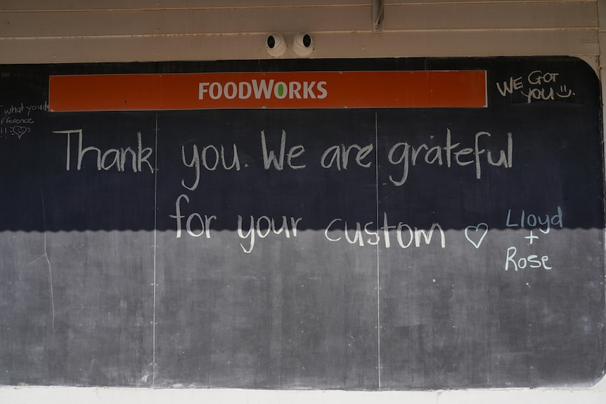 A chalkboard has the message 'Thank you. We are grateful for your custom' written on it