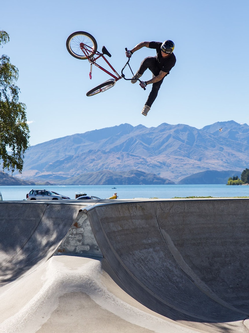 Professional freestyle BMX rider Logan Martin in the air in a skate bowl.