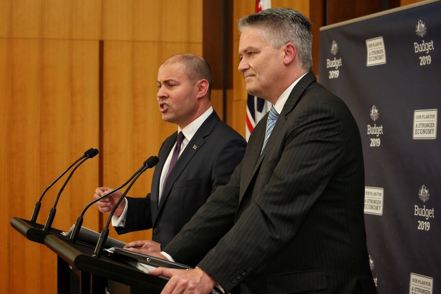 Josh Frydenberg and Mathias Corman stand at a podium delivering the federal budget on April 2, 2019.