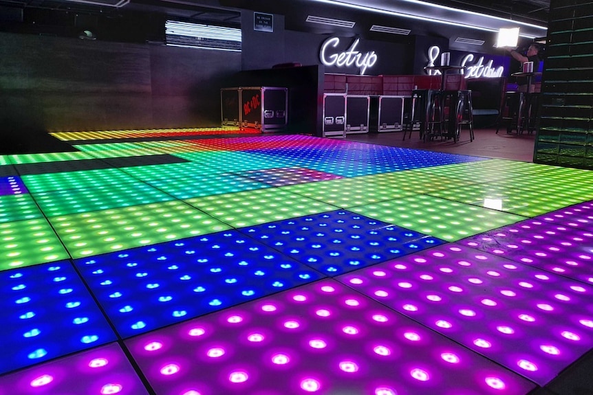 A technicolour neon dancefloor inside a club.