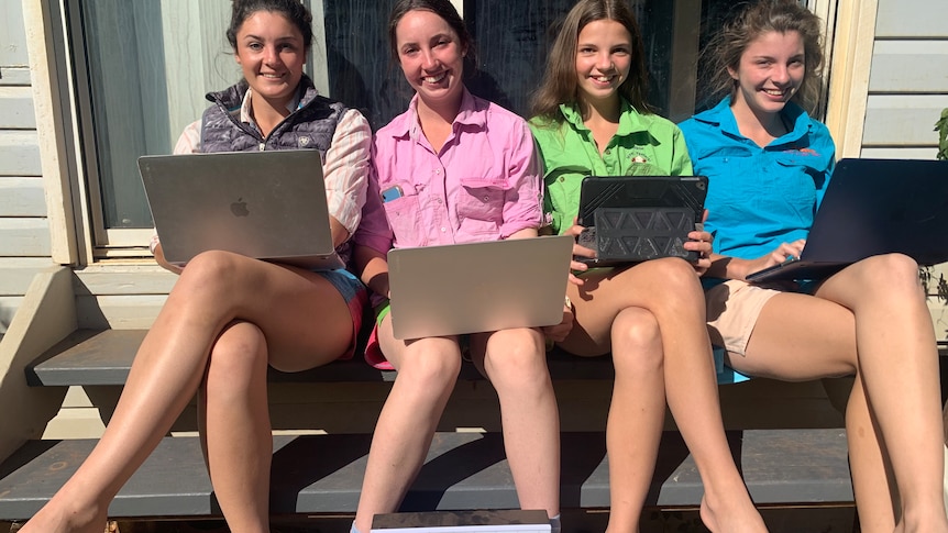 The four Henning girls sit at their Glenmorgan home with their laptops and tablets.