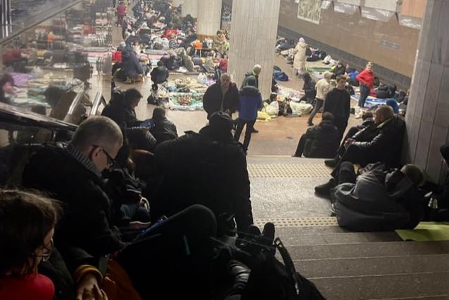People sitting down inside an underground railway station