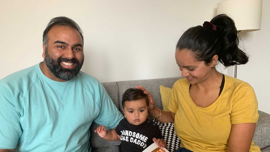 Prashant, right, is a man smiling in a bright green t-shirt and Simrat, right, a woman in a yellow t-shirt looks at child.