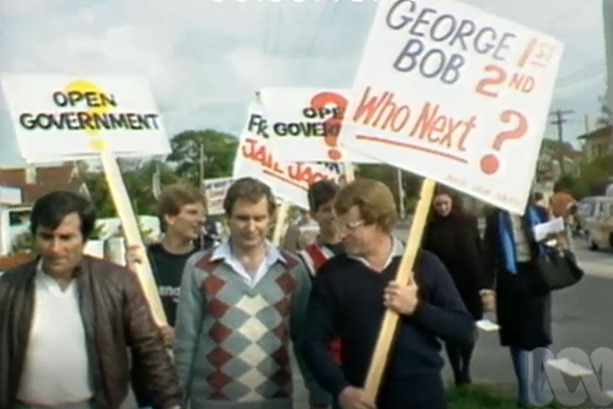 An old photo of a group of men holding protest signs.