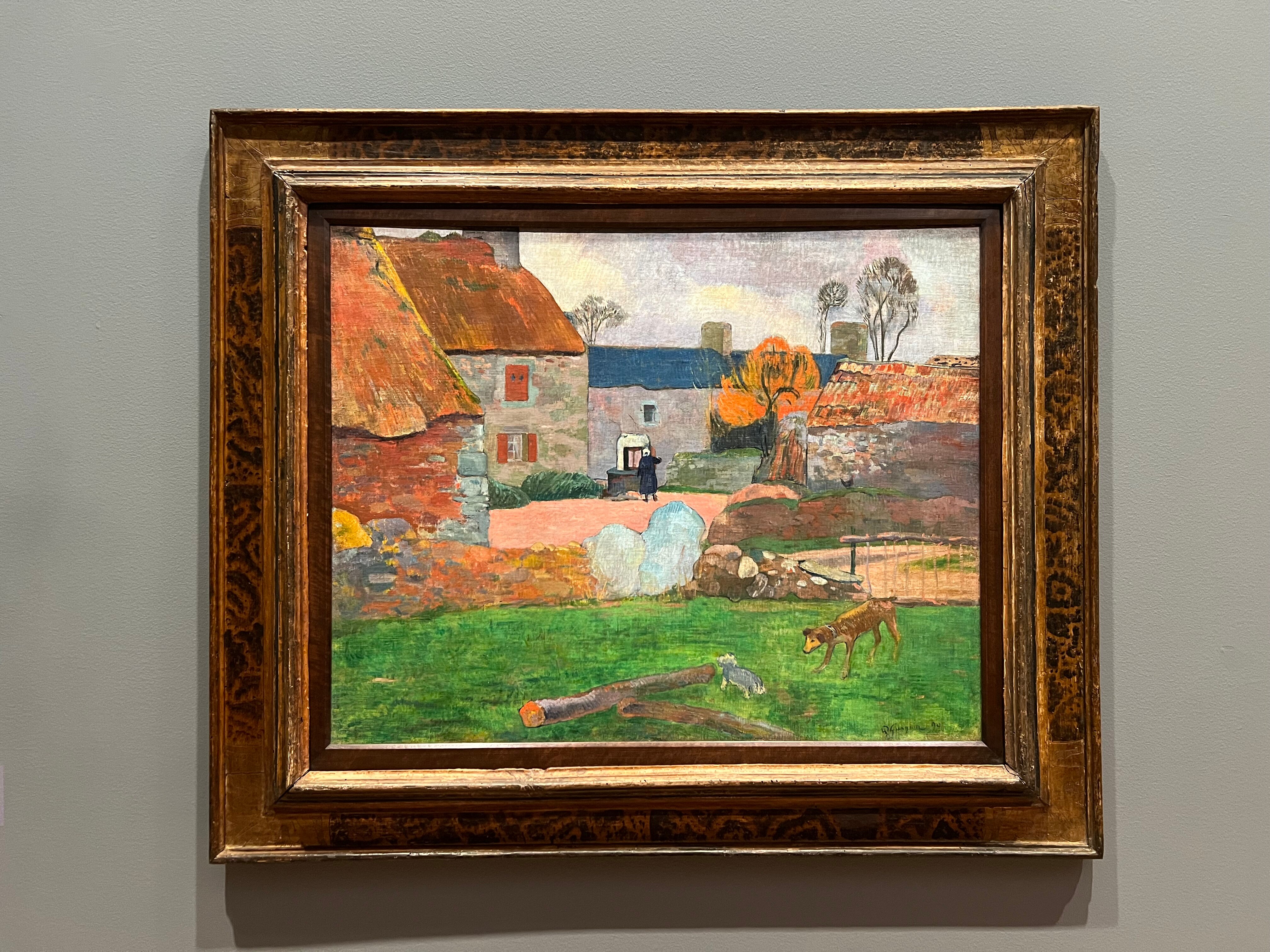 A post-impressionist painting of a green field with farmhouses behind, three with red roofs and one with a blue roof.