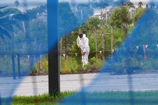 Worker in white hazmat suit cleans up asbestos at Rozelle Parklands