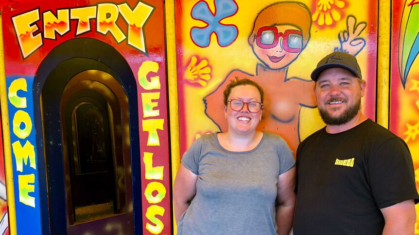 Couple standing in front of a carnival maze.