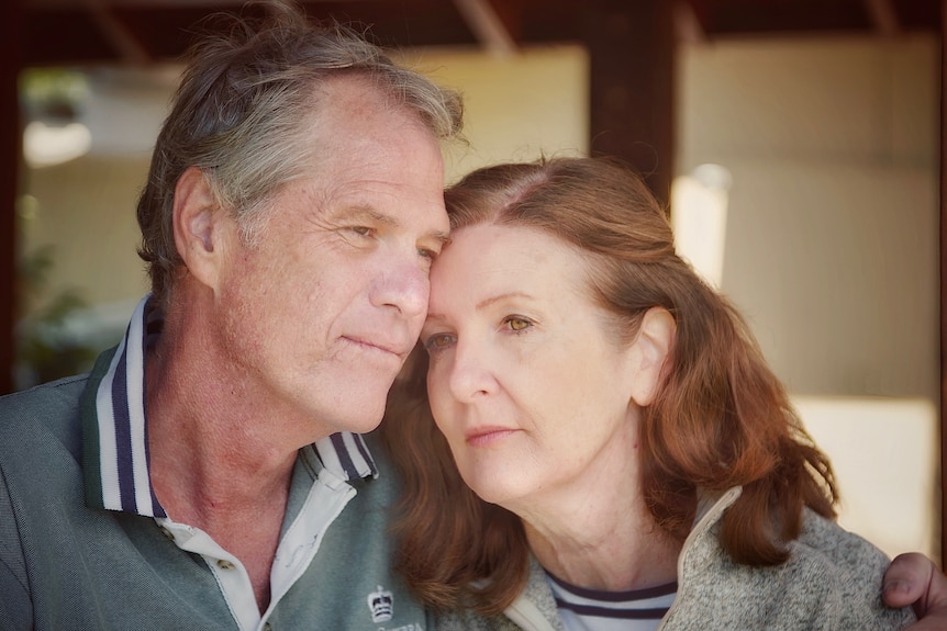 Husband and wife leaning on each other.