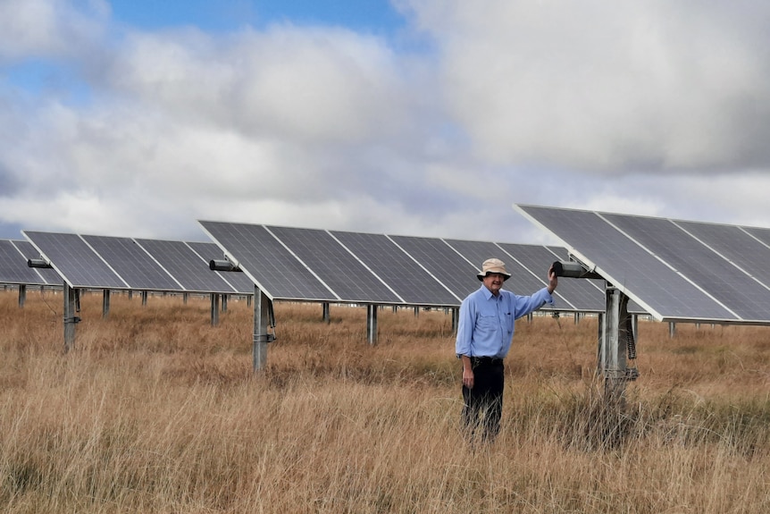 Tom Warren standing among the solar panels on his farm in Dubbo.