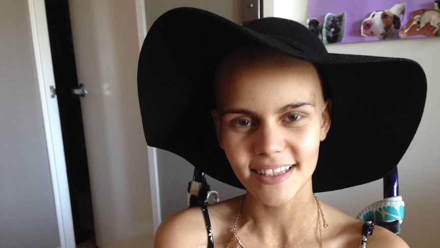 A young teenage girl wearing a big, floppy, black hat.