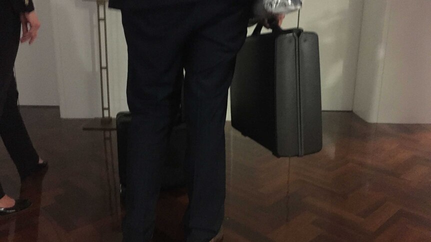 ASIO officer carrying briefcase.