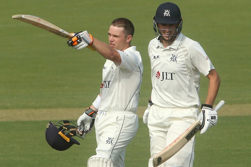 Marcus Harris points his bat to the crowd after scoring a century for Victoria in the Sheffield Shield final.