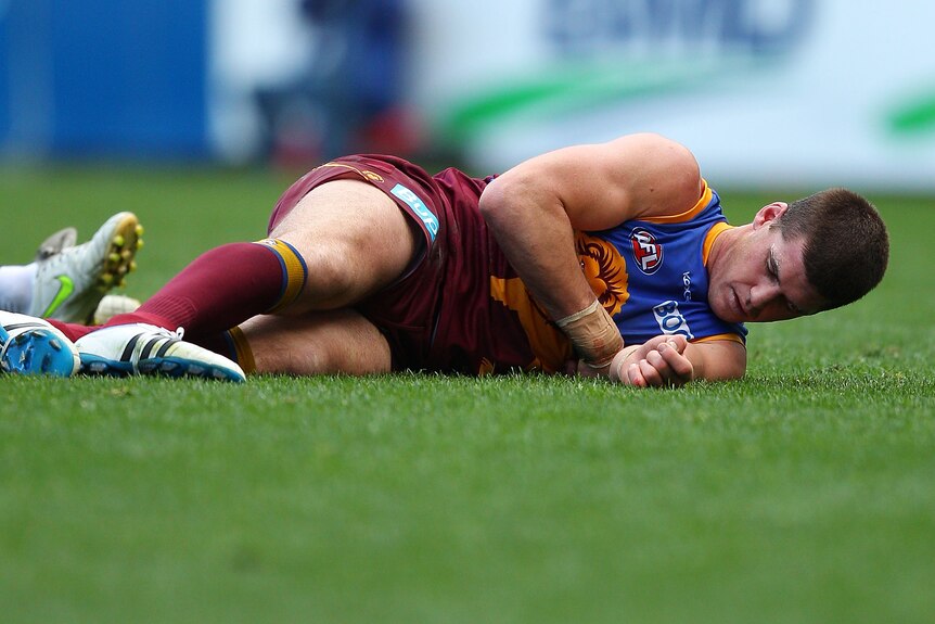 Jonathan Brown lies injured during the AFL match between the Brisbane Lions and the Geelong Cats.