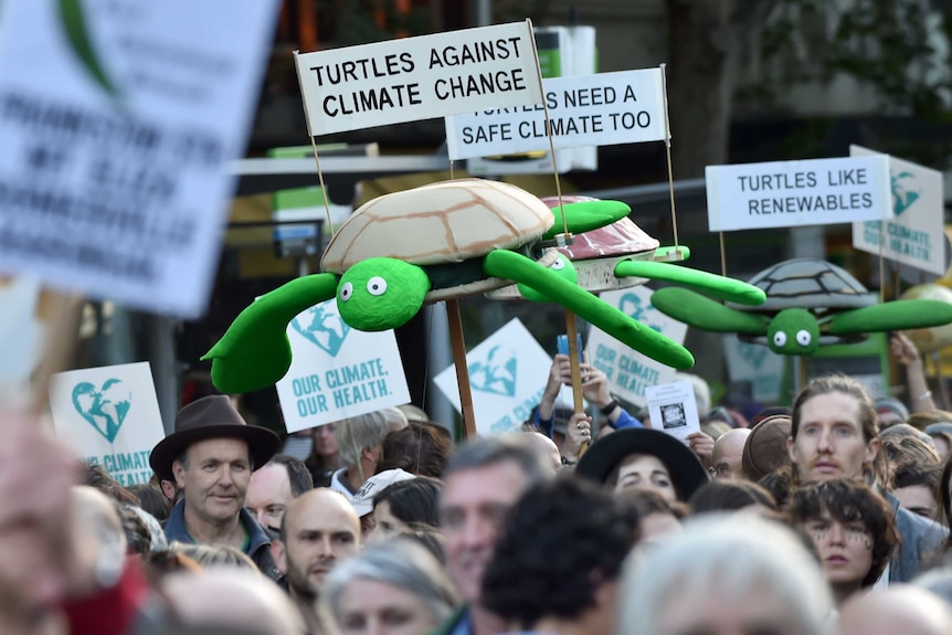 People march along a road during a rally calling for action on climate change in Melbourne on November 27, 2015.