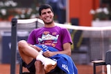 A tennis player smiles at the camera 