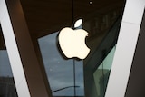 The window of an Apple store with a large Apple logo on it