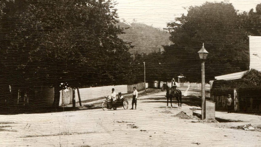 An old black and white photograph of four adults and a child at Stanley's main intersection circa 1900