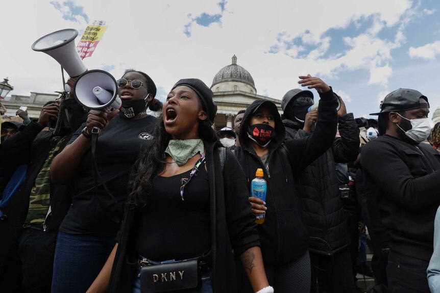Members of Black Lives Matter movement chant slogans with one using a megaphone.
