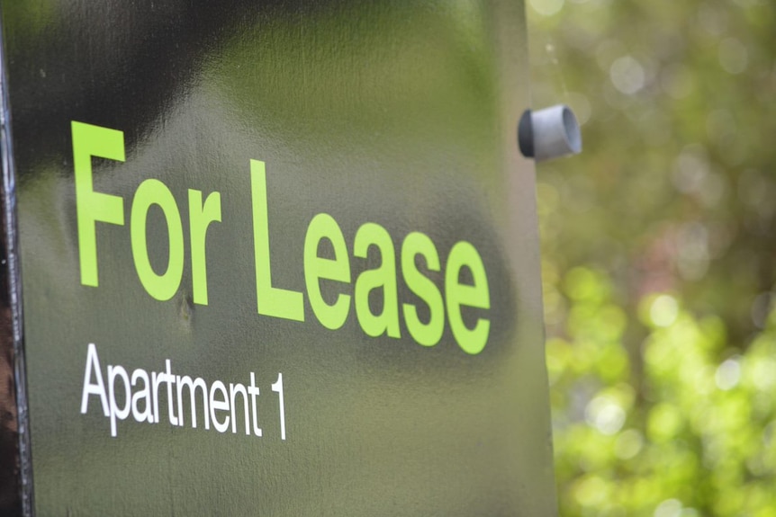 A black sign with green letters reading "For Lease, Apartment 1".