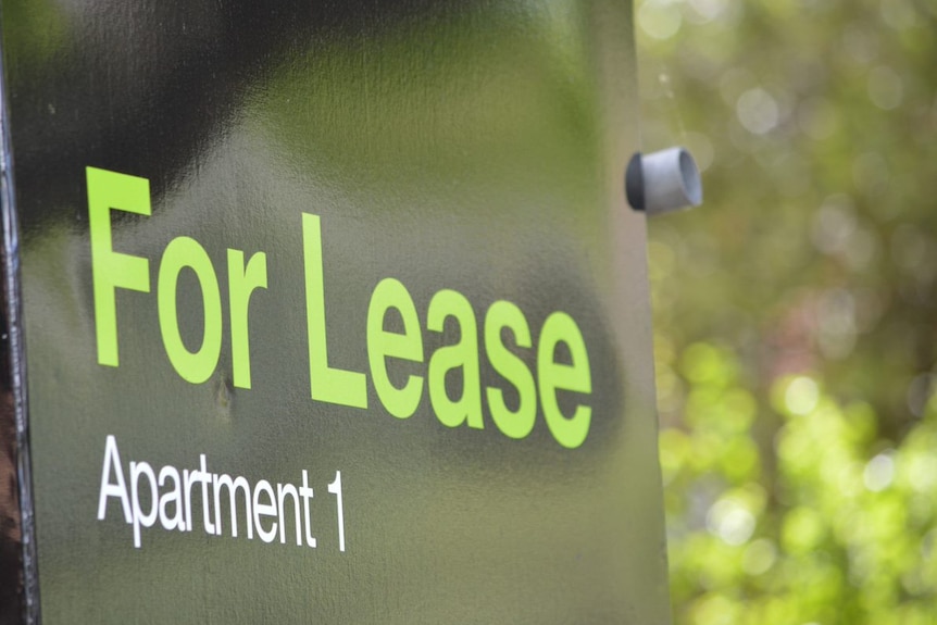A black sign with green letters reading "For Lease, Apartment 1".