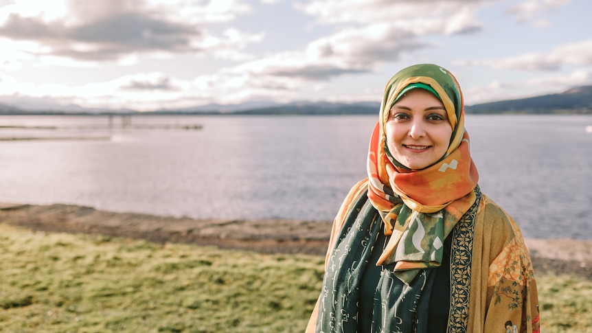 muslim woman with bright coloured hijab by a river