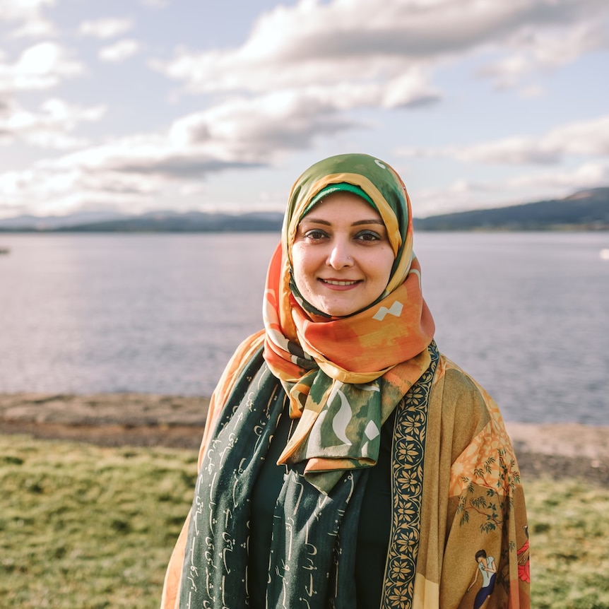 muslim woman with bright coloured hijab by a river
