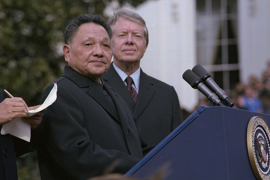  Deng Xiaoping stands behind a lecturn with Jimmy Carter.