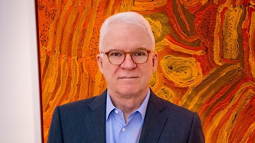 Actor Steve Martin in front of Indigenous artwork from his collection.