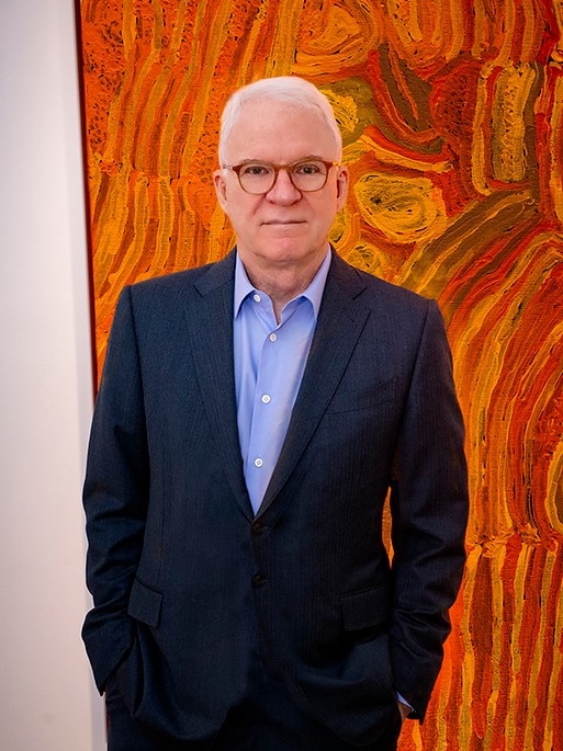 Actor Steve Martin in front of Indigenous artwork from his collection.