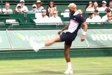 Benoit Paire kicks a yellow tennis ball with his left foot