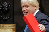 Boris Johnson holds a red folder and as he turns towards a door