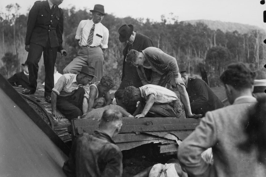 Rescuers search the train wreckage for survivors in the rail crash at Camp Mountain in 1947.