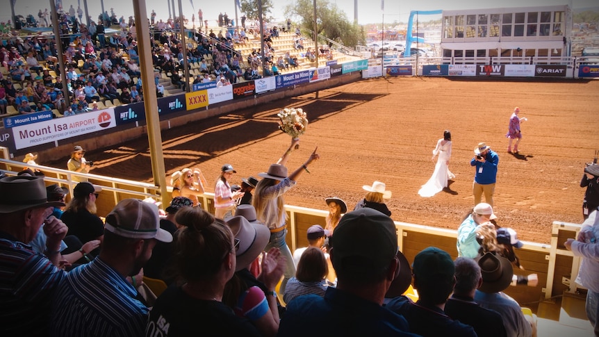 A shot of the bouquet toss taken from the crowd.