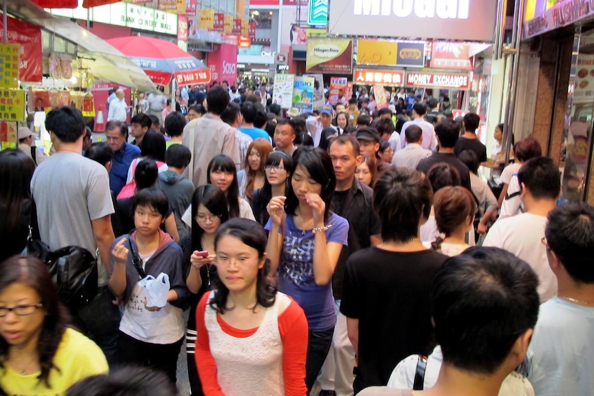 People make their way through the bustling Hong Kong district of Mong Kok