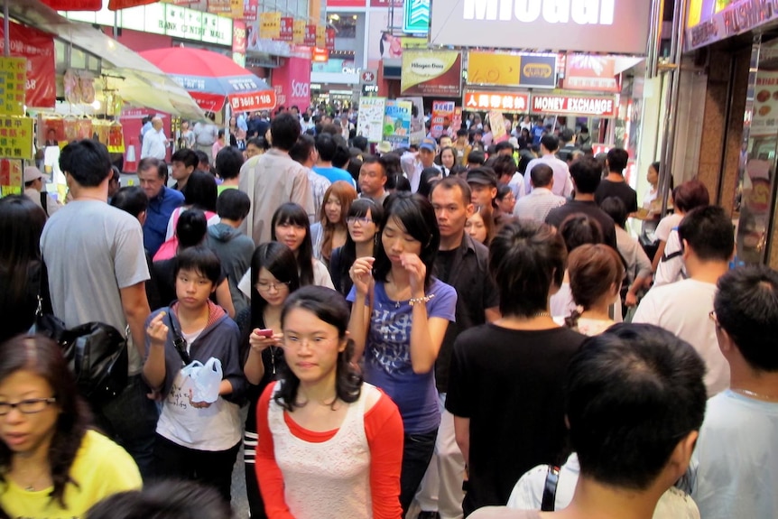 People make their way through the bustling Hong Kong district of Mong Kok.