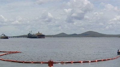 Floating booms are being used to help contain the oil spill in Gladstone Harbour.