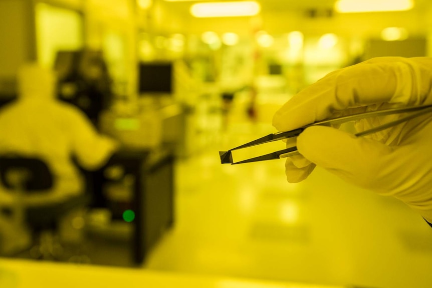 A quantum chip created at the UNSW Australian National Fabrication Facility held by tweezers.