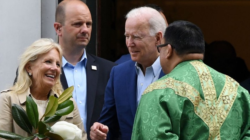 Us President Joe Biden and First Lady Jill Biden speak with a priest as they leave church
