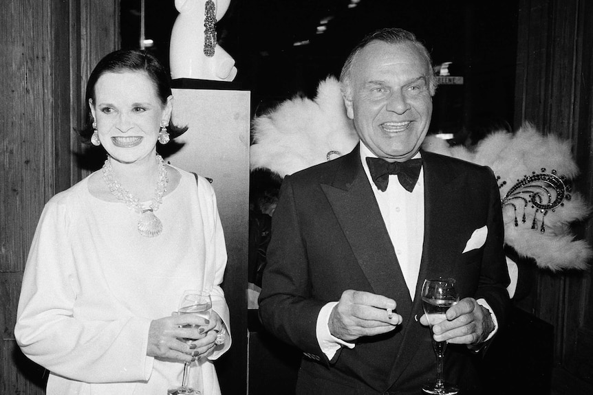 Gloria Vanderbilt and Bill Blass, wearing black-tie attire, stand next to each other