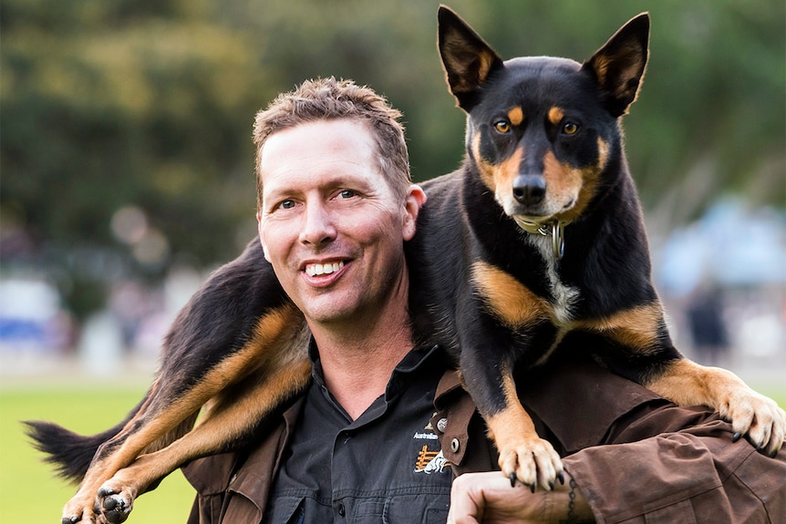 Carey Edwards with one of his rescue kelpies resting on his shoulders