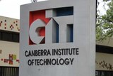 A sign reading Canberra Institute of Technology sits in front of a dark brown building.