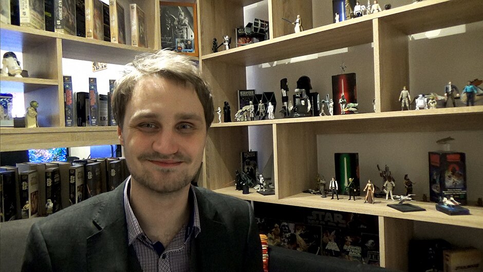 Petr Harmy sits in front of his Star Wars collection